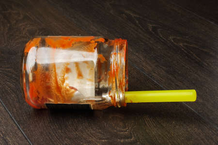 Eaten ketchup jar on the floorの写真素材