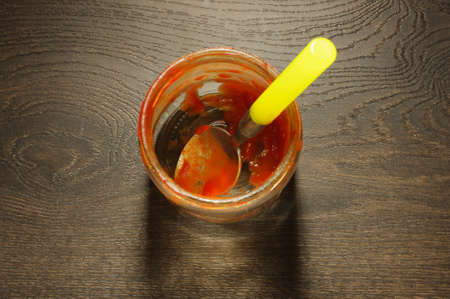 Messy tomato ketchup jar on the wooden floorの写真素材