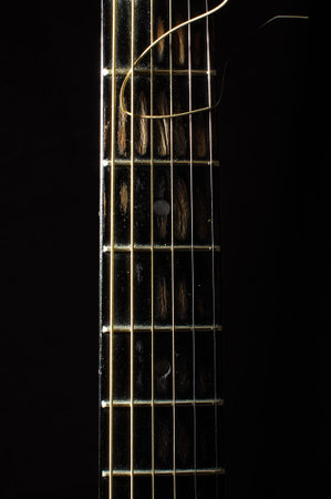 Acoustic 6 string guitar fretboard isolated on the black background