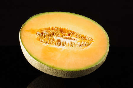 Cantaloupe melon fruit with reflection isolated on the black backgroundの写真素材