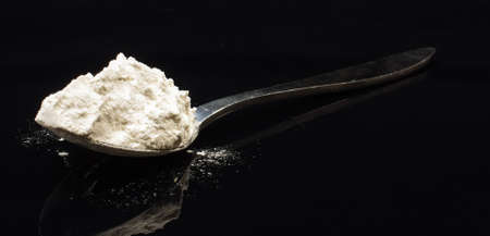 Full spoon of flour isolated on the black backgroundの写真素材