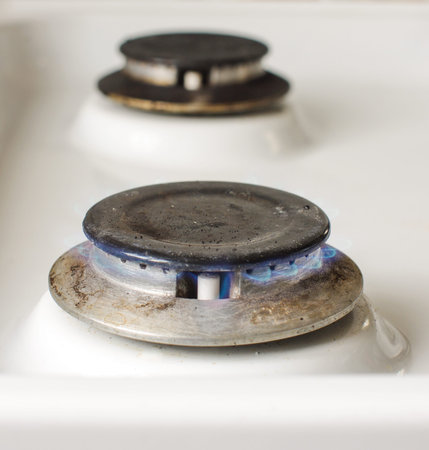 Vintage kitchen stove with blue gas flame close up