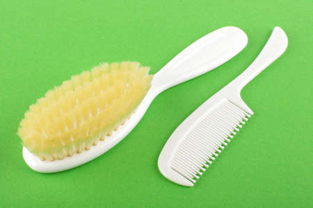 Baby hair care set of soft brush and comb isolated on the green backgroundの写真素材
