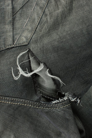Close up detail of black jeans with tears