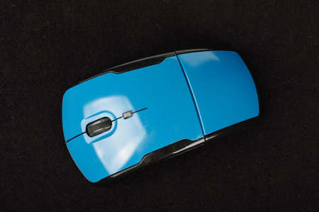 Blue wireless computer mouse top view isolated on the black backgroundの写真素材