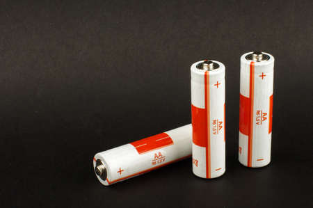 Three AA batteries isolated on the black background with copy spaceの写真素材