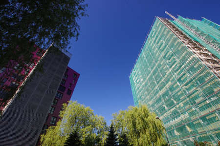 Modern house side by side to house under renovation wide angle viewの写真素材