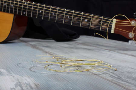 Brand new rolled phosphor bronze guitar strings on the wooden backgroundの写真素材