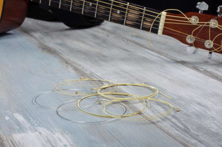 Golden bronze acoustic guitar strings in front of guitar fretboardの写真素材