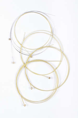 Brand new phosphor bronze guitar strings isolated on the white background ready for replacementの写真素材