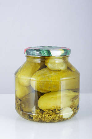 Pickled cucumbers in the jar isolated on the grey backgroundの写真素材