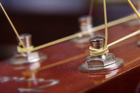 Abstract macro close up of acoustic guitar tuning machine and strings