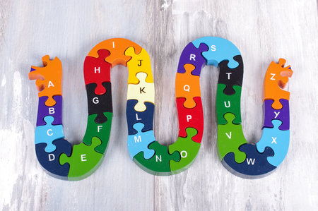 Alphabet snake puzzle game on the reclaimed oak surface