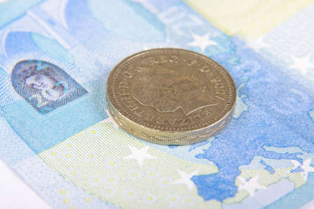 Great Britain Pound coin on the Euro banknote and Europe mapの写真素材