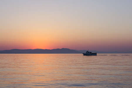 Small lonely boat in the sea at sunrise in Kos island, Greeceの写真素材