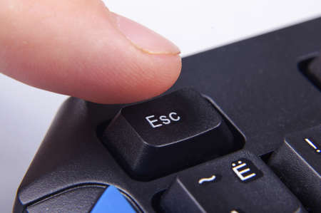 Finger pressing Esc button on computer keyboardの写真素材