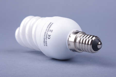 Compact fluorescent energy saving light bulb isolated on the gray backgroundの写真素材