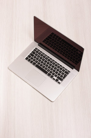 Modern laptop computer isolated on the white wooden background