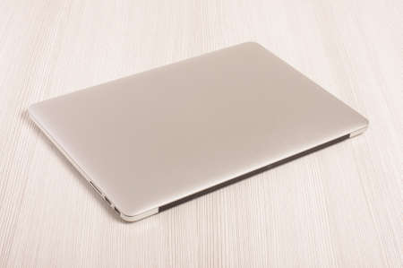 Modern laptop computer isolated on the white wooden backgroundの写真素材