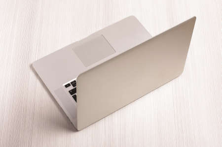 Modern laptop computer isolated on the white wooden backgroundの写真素材