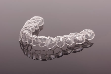Night guard teeth bruxism protection isolated on the dark background