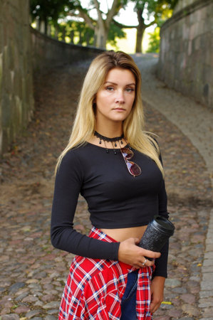 Young female holding take away coffee cup in the city