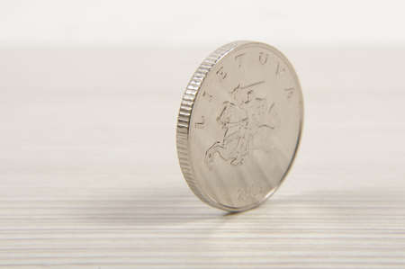 Metal coin standing on the rimの写真素材