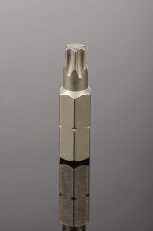 Torx screwdriver bit isolated on the black reflective backgroundの写真素材