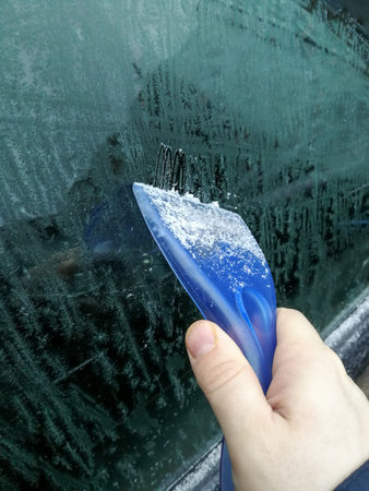 Ice scraper scratching iced car windscreen