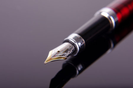 Luxury fountain pen isolated on the dark reflective background
