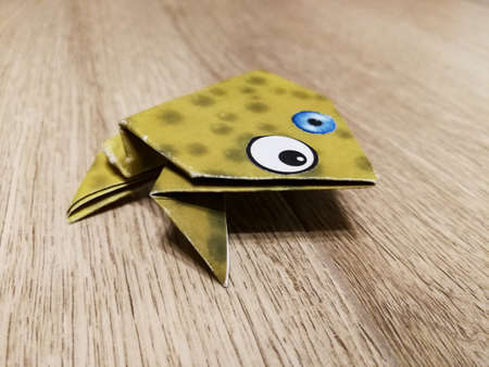Origami frog with crazy eyes folded from paper close upの写真素材