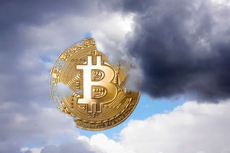 Bitcoin symbolic coin as a sun covered by cloudsの写真素材