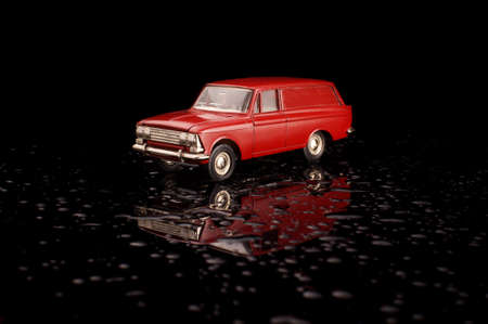Red soviet car die cast model on the black reflective backgroundの写真素材