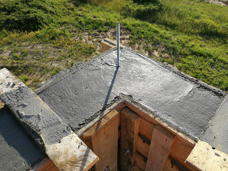 Metal screws inserted in the wet concrete for roof fixing of individual house