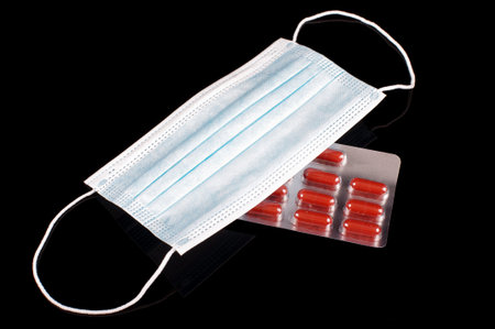 Medicine pills and virus protection face mask close up