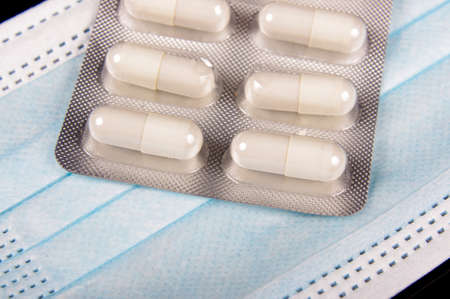 Medicine pills and virus protection face mask close upの写真素材