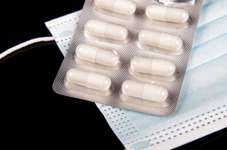 Medicine pills and virus protection face mask close upの写真素材