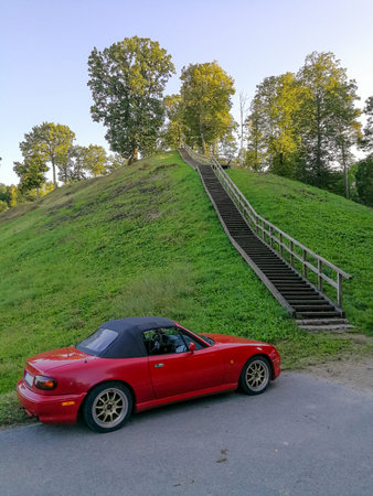 Zemosios Panemunes mound  with wooden stairs and modern car parked close by.  Travel concept