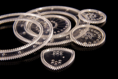 Plastic spirograph tool for drawing various curves for education isolated on the black reflective backgroundの写真素材