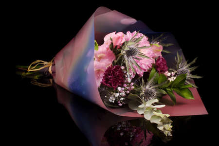 Modern bouquet of pink and purple pastel color flowers isolated on the black backgroundの写真素材
