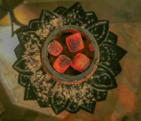 Photo of burning hookah square coal bricks made of coconut fiber