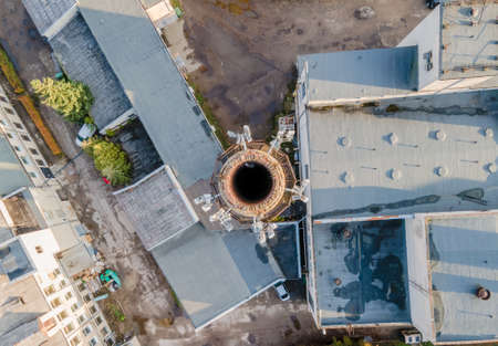 Aerial view of factory chimney in the city with 4G, 5G cellular network antennasの写真素材