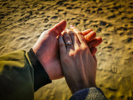 Engagement moment when girl says yes at a beach in front of sea, eaves and horizon