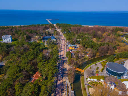 Aerial view of main pedestrian Basanavicius street in spring in Palanga resort, Lithuania with many people walking in it and heading to pedestrian bridge on shore of Baltic seaの写真素材
