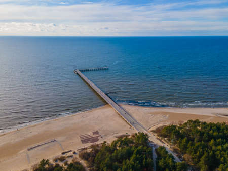 Aerial view of Palanga pedestrians bridge to the sea and coastline with sandy beach and blue cloudy skyの写真素材