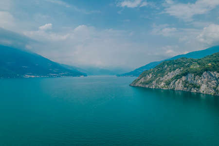 Photo of foggy mountains in Como lake in Lombardy, Italy. Sunset view over the mountainの写真素材