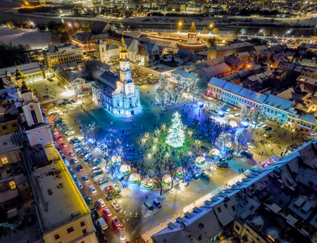Aerial panoramic drone photo of Kaunas Old Town with a Christmas market and a Christmas tree with decorations at nightの写真素材