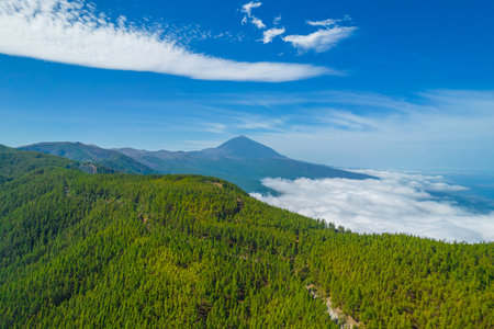 Aerial photo of mount Teide in the distance above the clouds. Volcano in Teide national park in Tenerife island, Spain.の写真素材