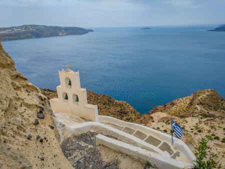 Three bells on the cliff in Santorini island in front of Aegean seaの写真素材