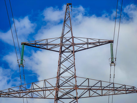 High voltage line poles and wires with blue sky and white clouds backgroundの写真素材